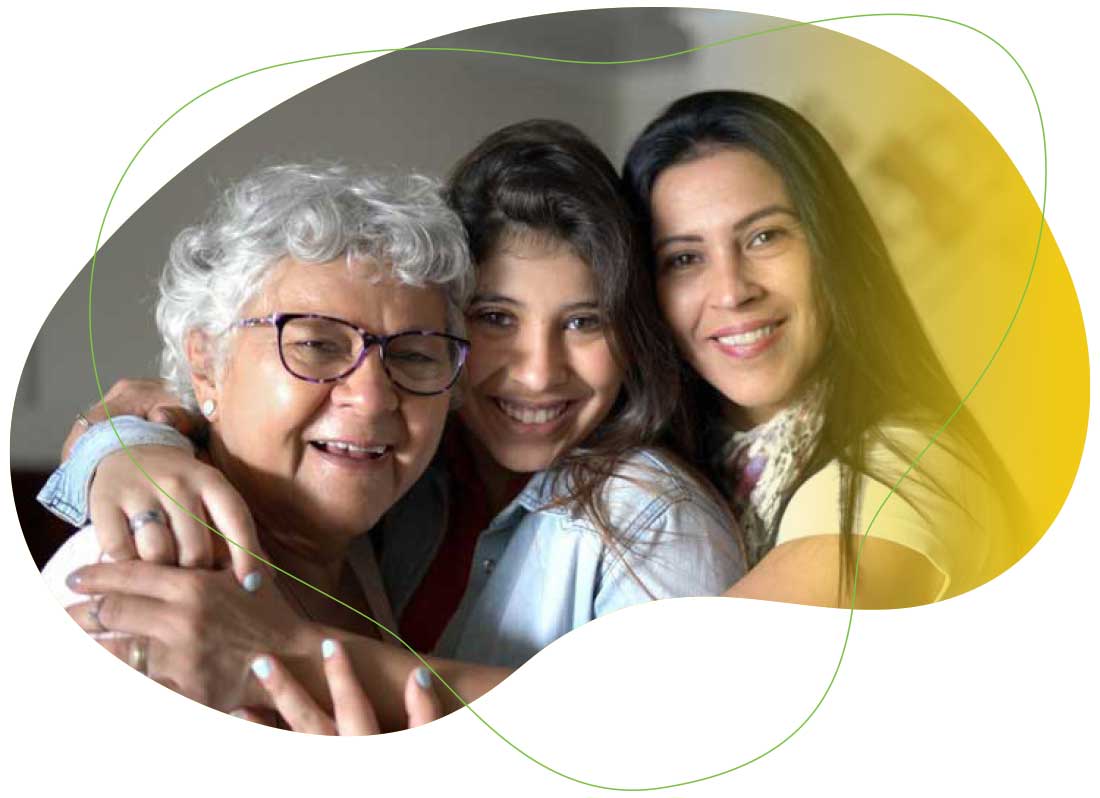 Three smiling women embracing and looking at the camera.