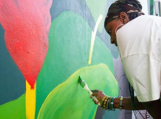 Woman painting mural at Artserve
