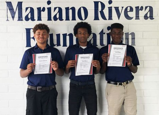 Three boys holding certificate of completion from Mariano River Foundation